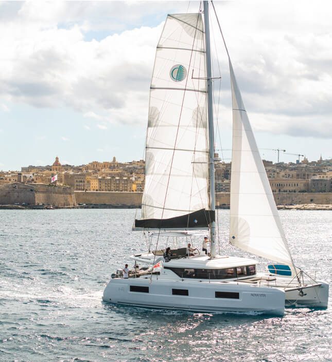 Lagoon 46 'Nova Vita' catamaran sailing past Valletta, Malta